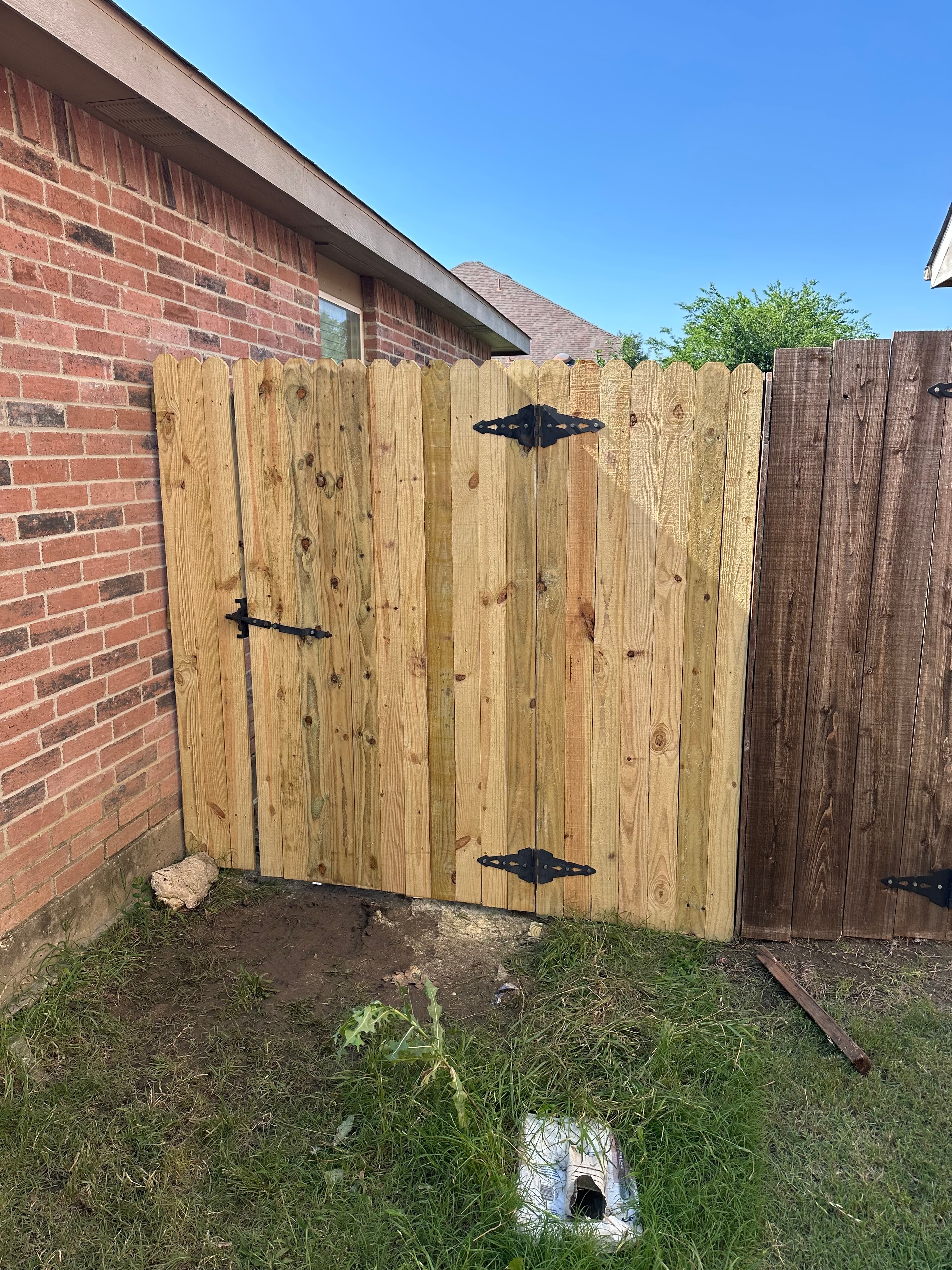 New wood gate installation with black hardware